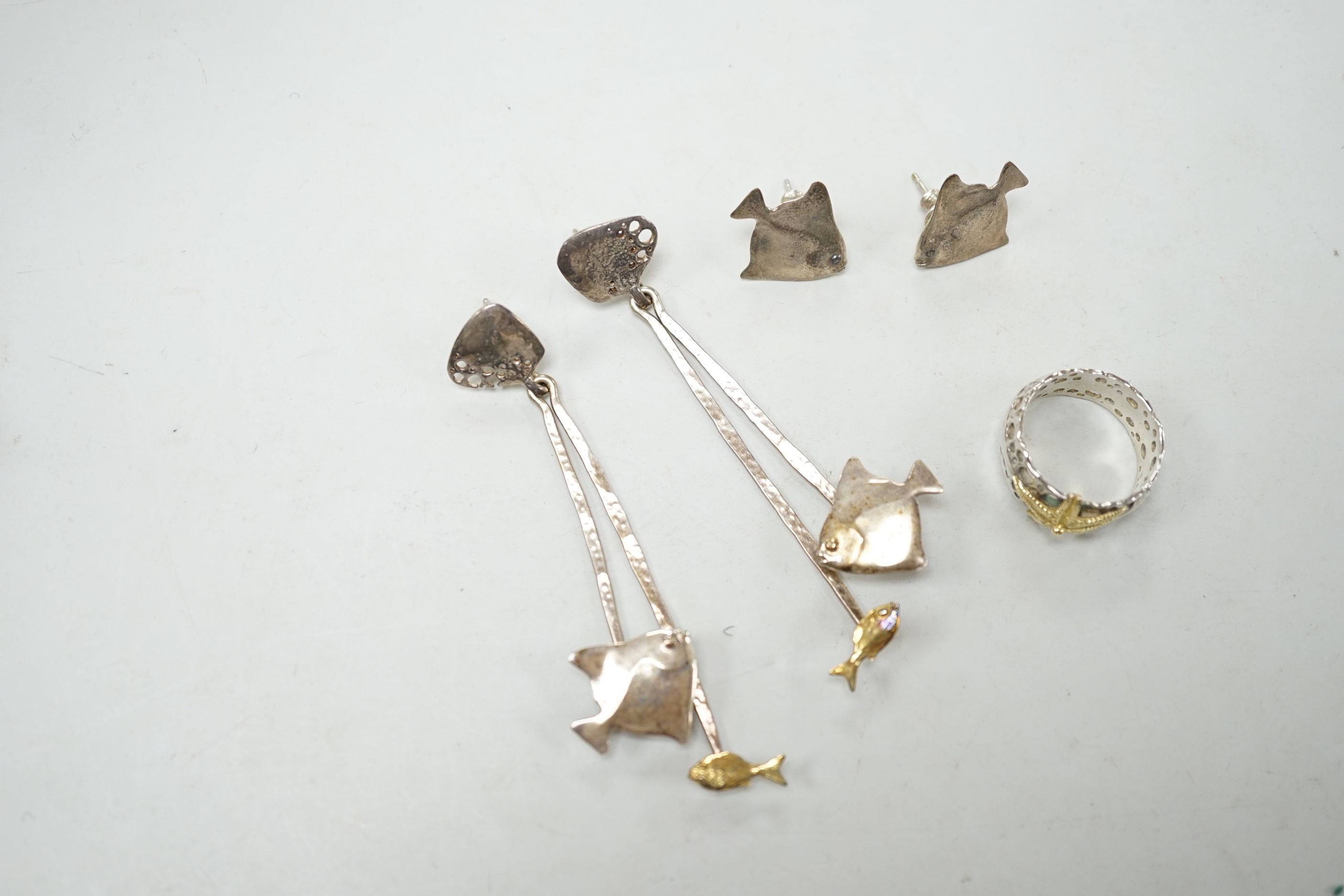 A modern Alan Vallis parcel gilt silver ring, with starfish motif, size O and two pairs of Alan Vallis silver earrings, both modelled with fish, longest overall 74mm.
